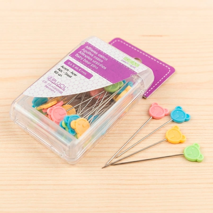Alfileres de patchwork con cabeza de pajarito en colores suaves, presentados en caja de 60 unidades.