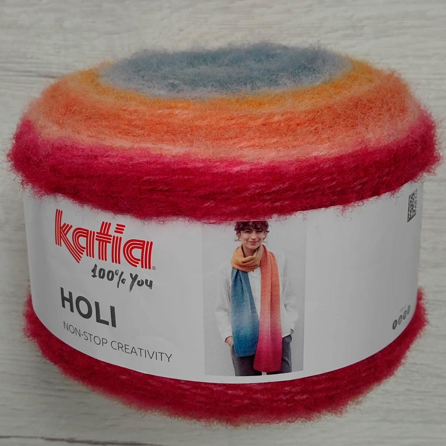 Ovillo de lana Katia Holi color 505 con degradado multicolor desde fucsia intenso hasta azul grisáceo, mezcla de lana y fibras premium.