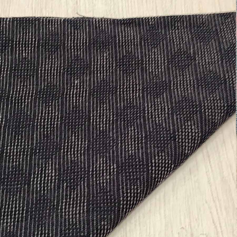 Primer plano de tela japonesa gris carbón oscuro con delicada trama geométrica en hilo claro y acabado profesional.